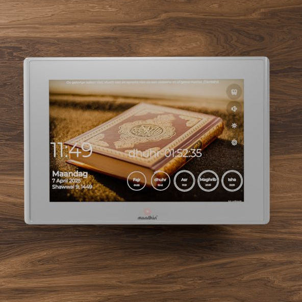 Digitale adhan klok op een houten oppervlak, met een onscherpe achtergrond.