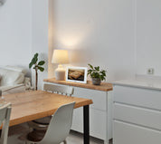 Muadhin gebedsklok op een dressoir naast een lamp en plant in een moderne eetkamer