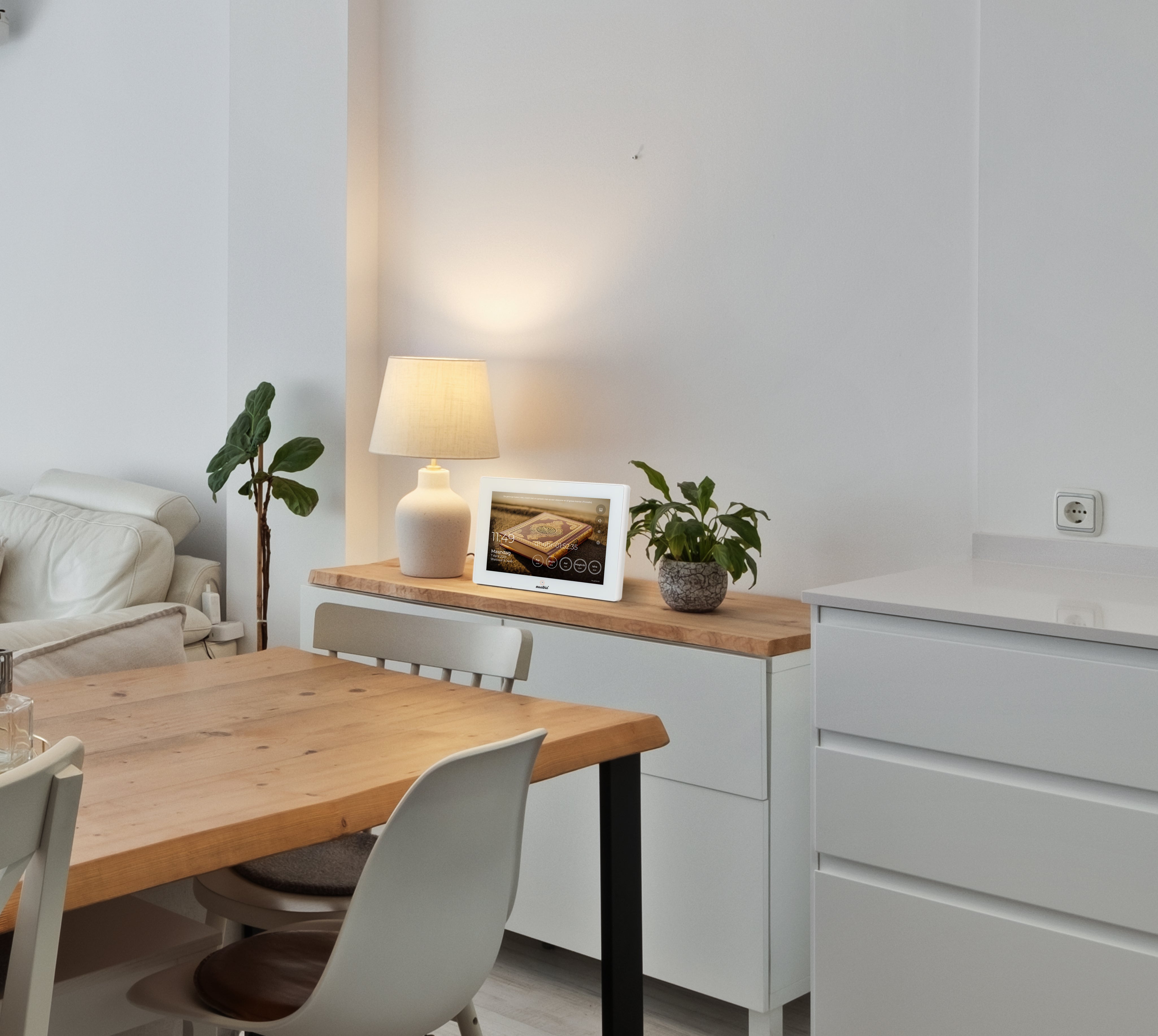 Muadhin gebedsklok op een dressoir naast een lamp en plant in een moderne eetkamer