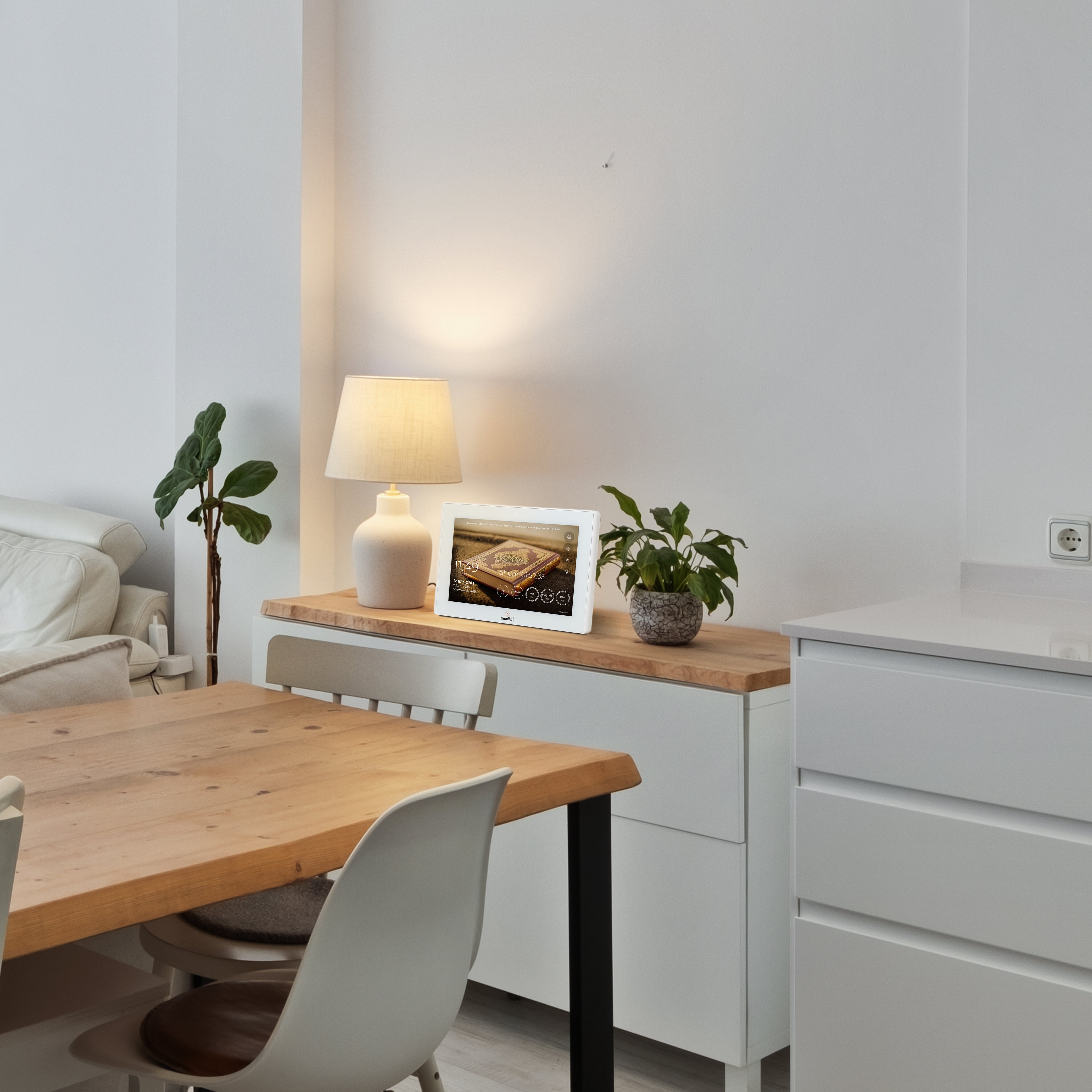 Muadhin gebedsklok op een dressoir naast een lamp en plant in een moderne eetkamer
